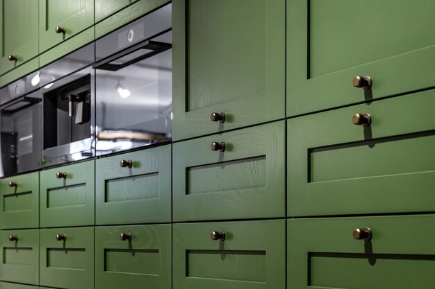 Large green kitchen cabinet with many handles closeup