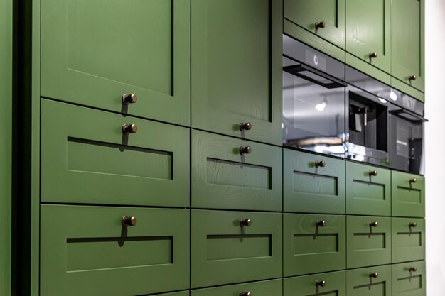 Large green kitchen cabinet with many handles closeup