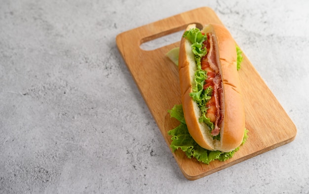 Foto gratuita grande hot dog sul tagliere di legno