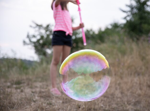 Large multicolored soap bubble on a blurred background.