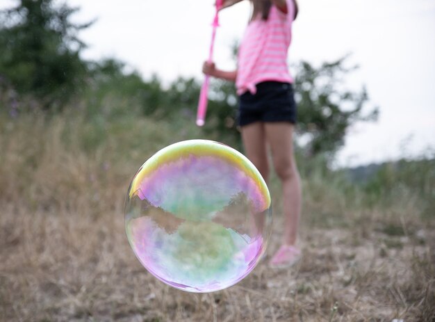 Large multicolored soap bubble on a blurred background.