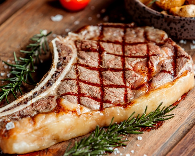 A large piece of steak with tarragon leaves