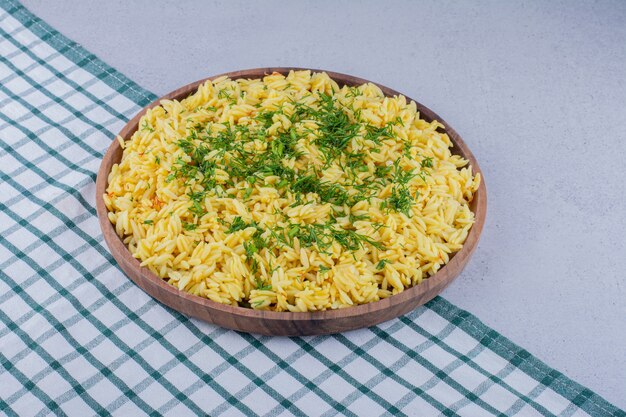 Large pilaf serving garnished with chopped dill on marble background. High quality photo