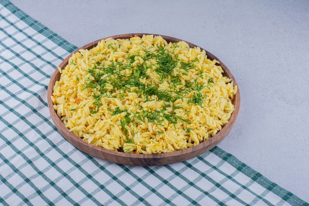 Large pilaf serving garnished with chopped dill on marble background. High quality photo