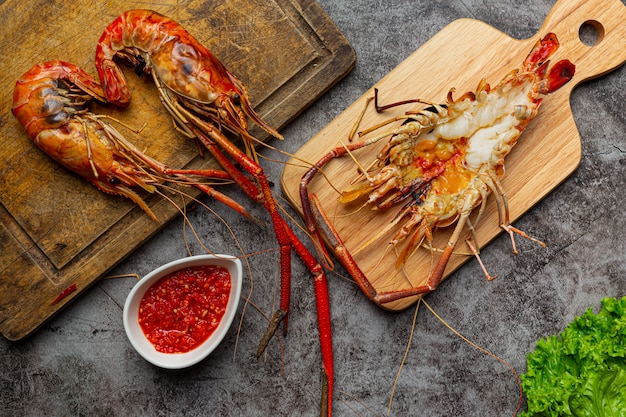 Free photo large river prawns grilled and ready to eat decorated with beautiful side dishes.