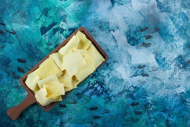 Foto gratuita fogli di lasagne su una tavola, sul tavolo blu.