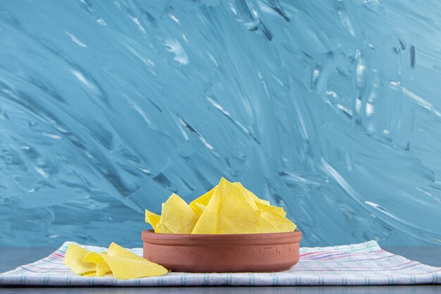 Lasagna sheets in a bowl on a towel , on the marble background.