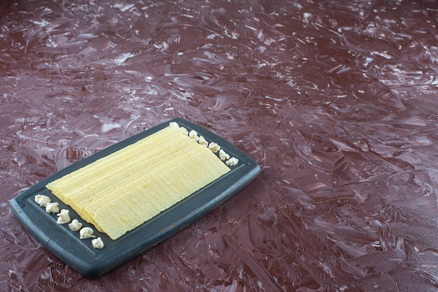 Foto gratuita fogli di lasagne e maionese su vassoio di legno, sul tavolo di marmo.