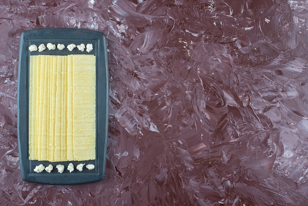 Lasagna sheets and mayonnaise on a wooden tray , on the marble table. 