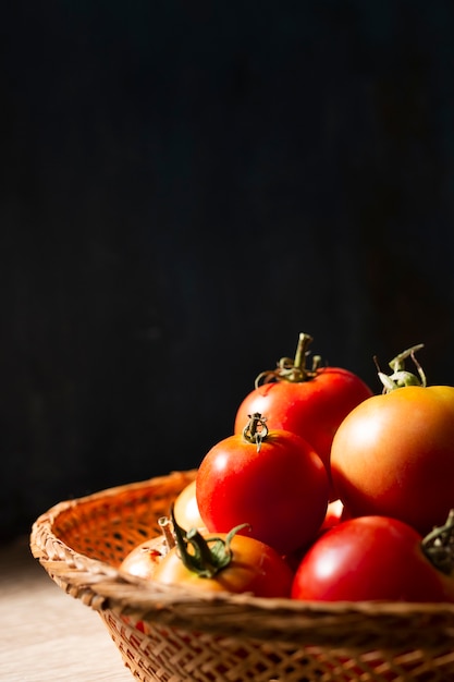 Free photo lateral view basket full with tomatoes