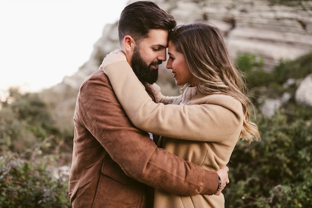 Free photo lateral view couple embracing in nature