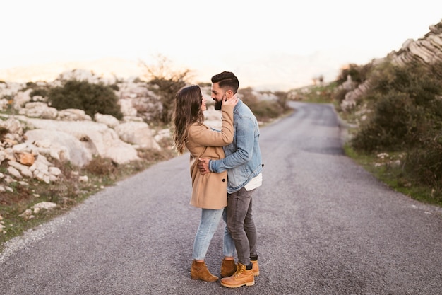 Lateral view couple embracing on road