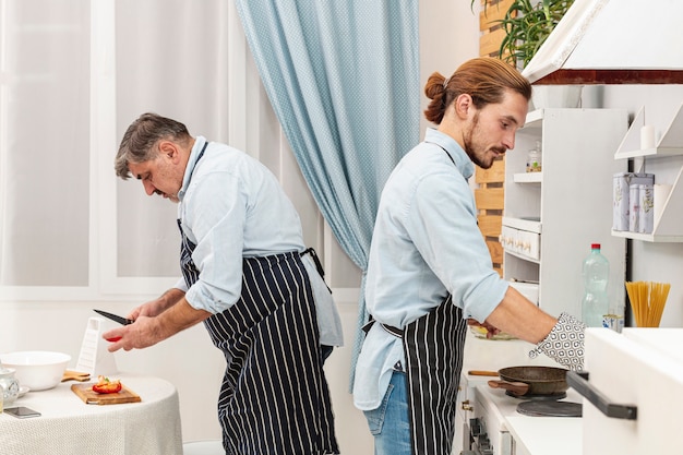 Free photo lateral view father and son cooking