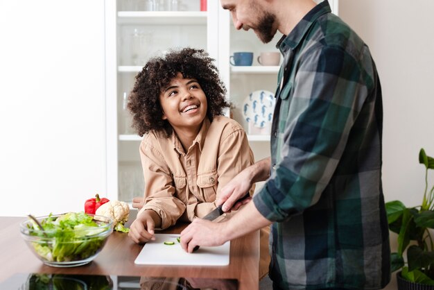 Vista laterale uomo e donna che cucinano insieme