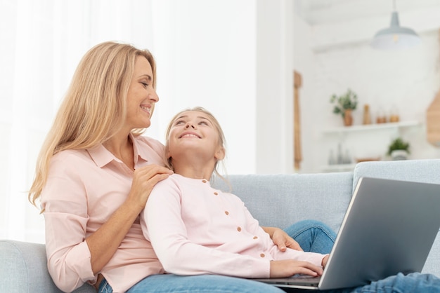 Lateral view mother and daughter working on laptop