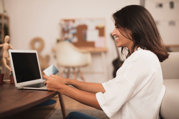 Lateral view of a woman working on laptop mock up