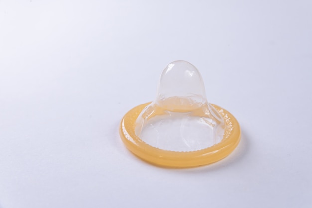 Latex condom on white surface