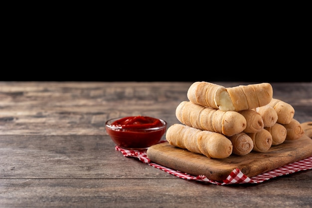 Latin American tequeÃÂ±os stuffed with cheese on wooden table