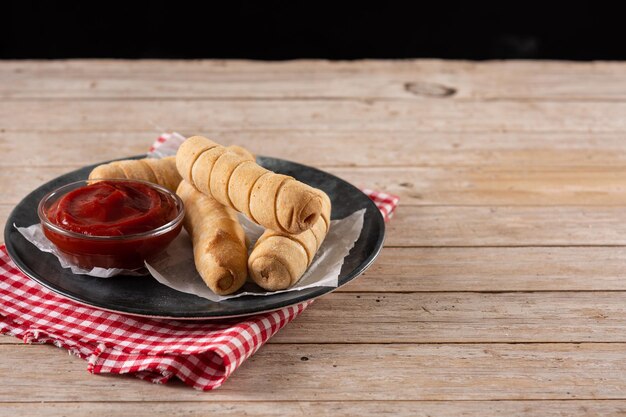 Latin American tequeÃ±os stuffed with cheese on wooden table