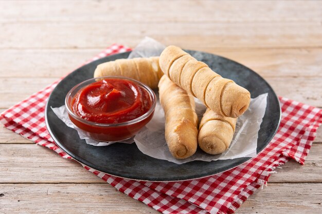 Latin American tequenos stuffed with cheese on wooden table