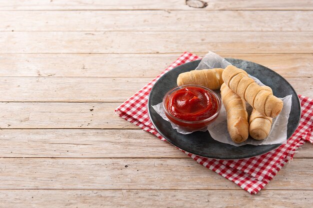 Latin American tequenos stuffed with cheese on wooden table