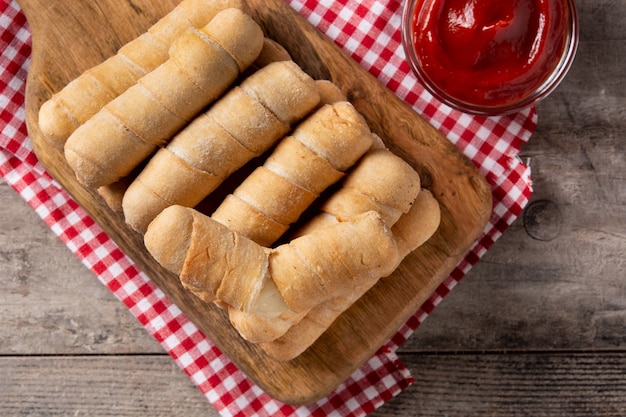 Latin American tequeos stuffed with cheese on wooden table