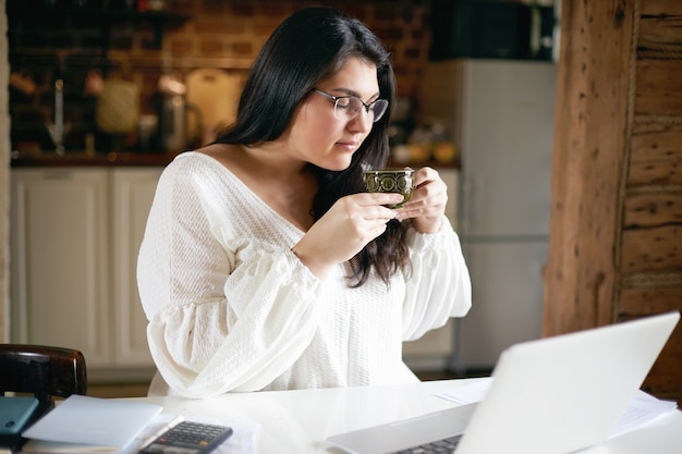 Ragazza castana latina che posa dell'interno