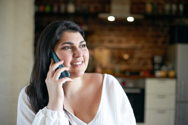 Ragazza castana latina che posa dell'interno