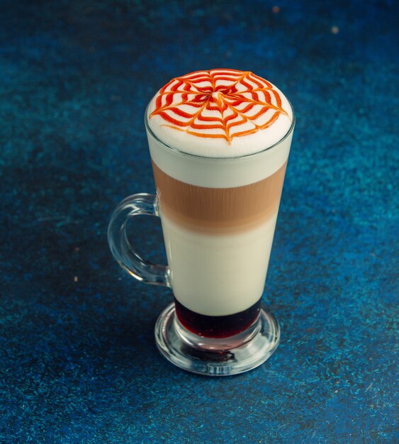 latte macchiato with whipped cream and caramel strips on top