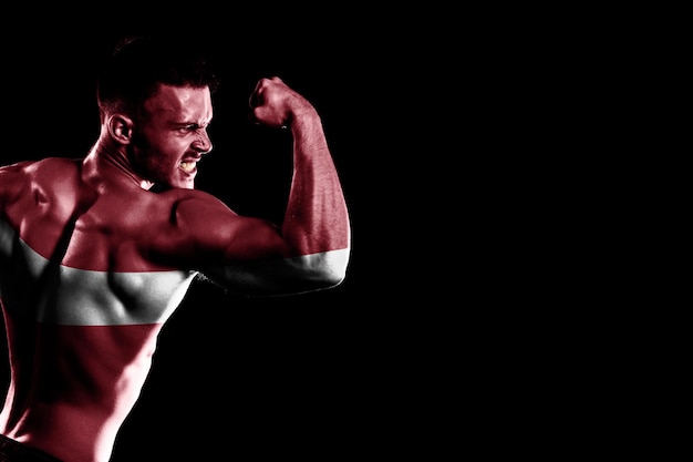 Free photo latvia flag on handsome young muscular man black background