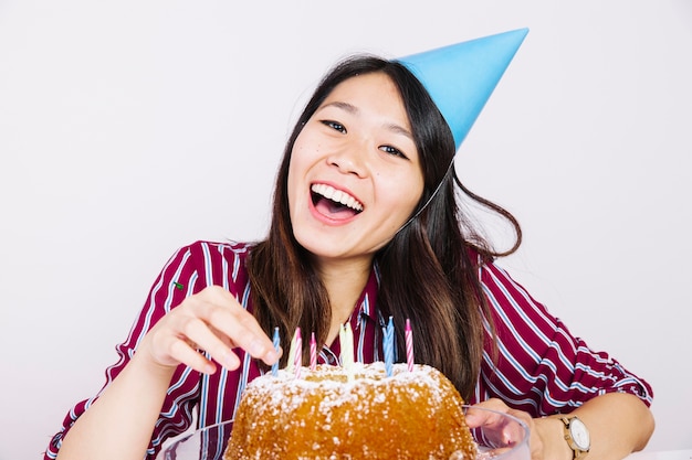 Laughing birthday girl in front of cake