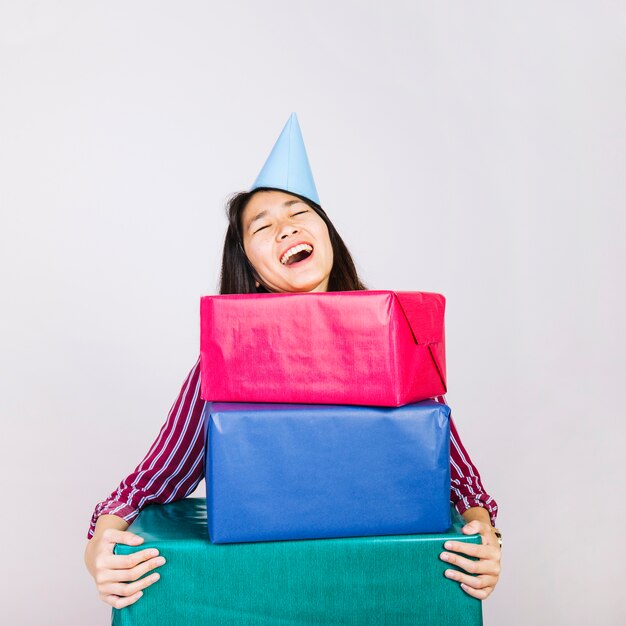 Laughing birthday girl with present boxes