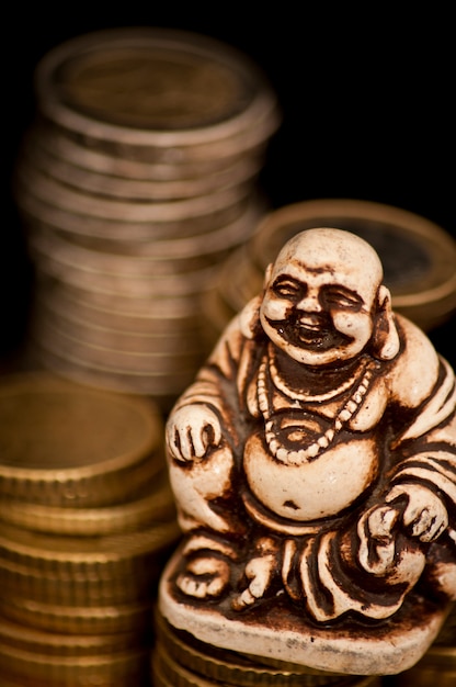 Laughing Budda in front of coins