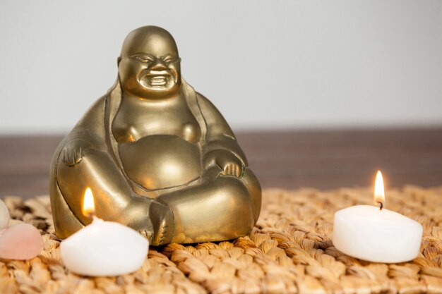 Laughing buddha figurine and lit candles