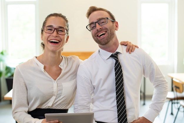 Laughing business people using tablet computer.