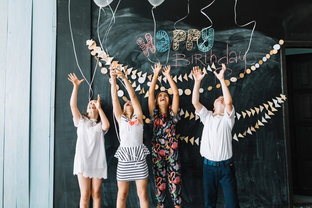 Laughing children releasing balloons