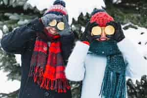 Free photo laughing couple covering eyes with lemons