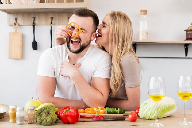 Laughing couple playing with bell pepper