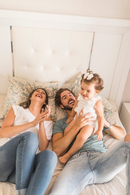 Laughing couple playing with daughter