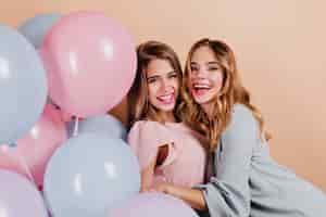 Free photo laughing curly ladies embracing her friend at party