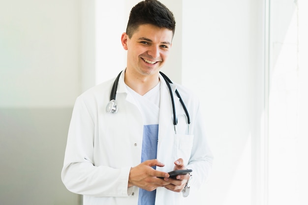 Laughing doctor with smartphone