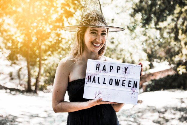 Laughing enchantress with signboard in sunlit forest