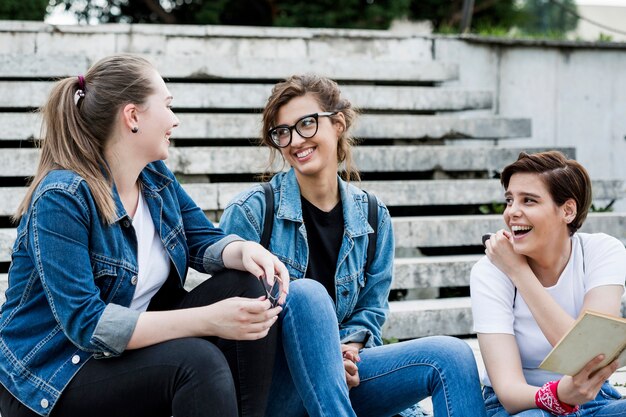 Laughing female friends sitting on stairs