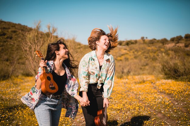 Laughing female friends with ukuleles