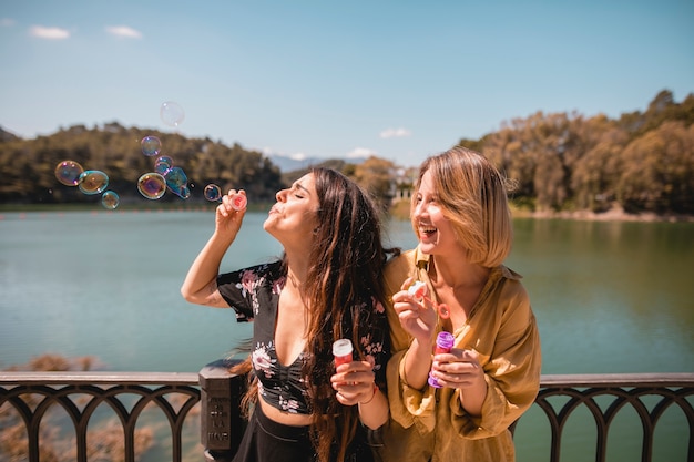 Free photo laughing friends blowing bubbles