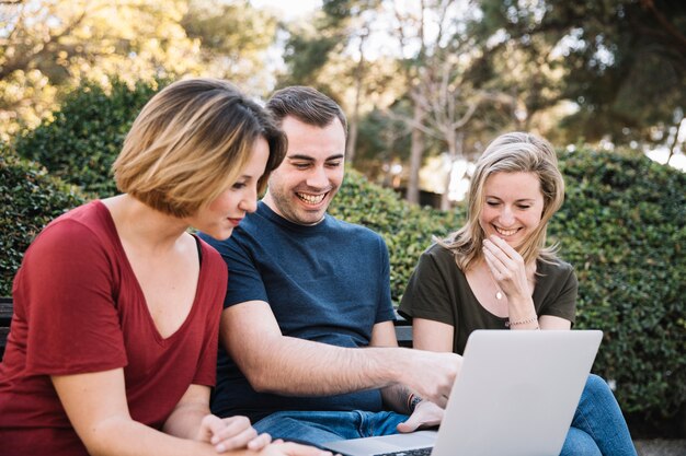 Laughing friends pointing at laptop screen