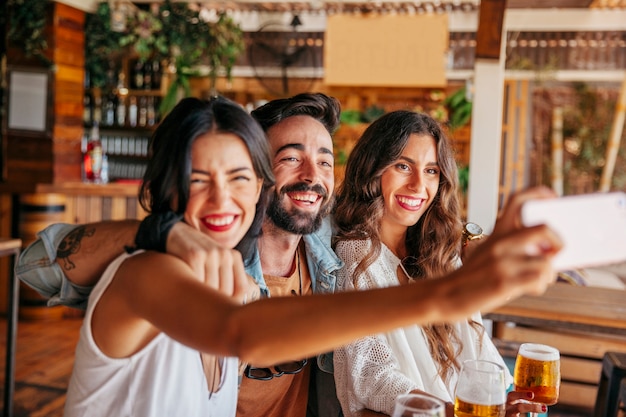 Ridere amici che prendono selfie