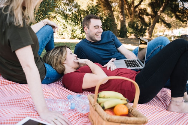 Free photo laughing friends watching movie on laptop