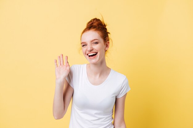 Laughing ginger woman waving