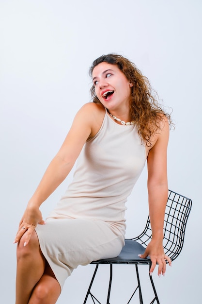 Free photo laughing girl is looking away by sitting on white background